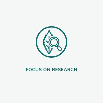 Within the circle is a sketch of a leaf with a magnifying glass. Beneath the circle the words read: Focus on research. Our scientists are passionate about finding treatments to improve lives.