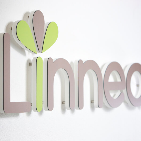 The company's name in grey. The words read Linnea. The I in Linnea is light green in color and has 3 sprouting leaf-like icons to mark the dot on the i.